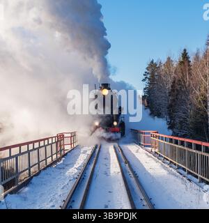 Le train à vapeur rétro arrive au matin d'hiver. Banque D'Images