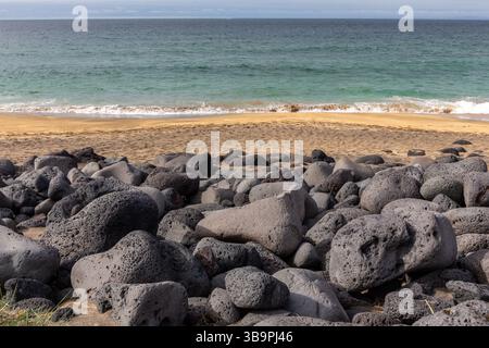 Cailloux volcaniques noirs et pierres sur la plage de Skardsvik sur la péninsule de Snaefellsnes en Islande, plage de sable doré avec de l'eau turquoise, les vagues s'écrasent. Banque D'Images