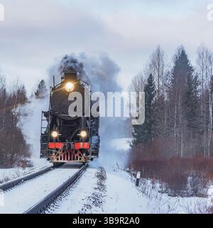 Le train à vapeur rétro arrive au matin d'hiver. Banque D'Images