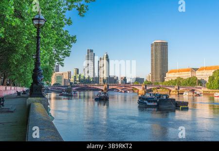 Les gratte-ciel londoniens modernes le long de la Tamise, avec le pont Vauxhall, la verdure au bord de la rivière et les gratte-ciel saisissants par un matin d'été clair Banque D'Images
