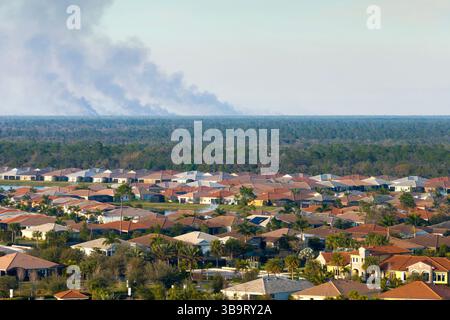 Quartier de banlieue en Floride souffrant de mauvaise qualité de l'air pollué par la fumée prescrite de feu de forêt Banque D'Images