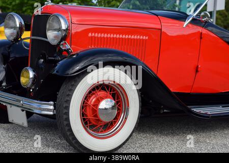 28 mai 2022 - East Gwillimbury, Ontario, Canada : vue du phare avant et de la roue Goodyear de la vieille voiture classique Ford rouge vintage 1932 modèle B. Banque D'Images
