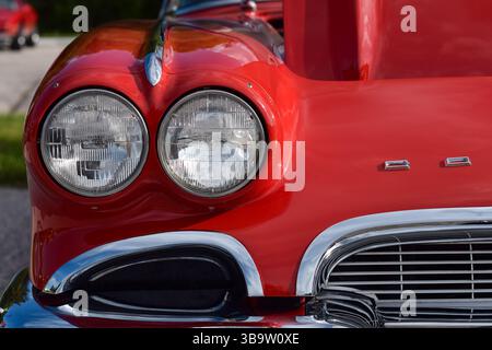 28 mai 2022 - East Gwillimbury, Ontario, Canada : gros plan sur le phare avant d'une vieille Chevrolet Corvette rouge classique 1961 Banque D'Images