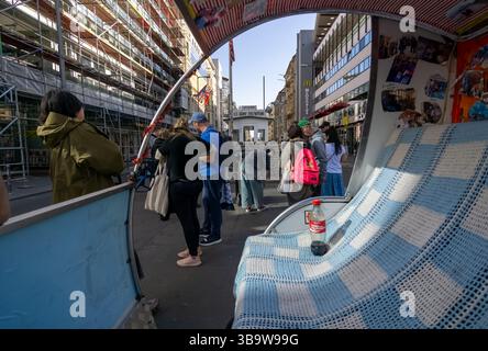 Checkpoint Charlie vu de l'intérieur d'un pousse-pousse à vélo coloré avec des touristes se rassemblant autour du site historique de la Guerre froide à Berlin. Banque D'Images