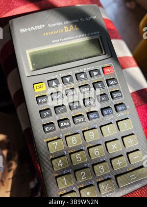 Gros plan de la calculatrice scientifique SHARP El-531RH en lumière naturelle sur fond de tissu rayé Banque D'Images