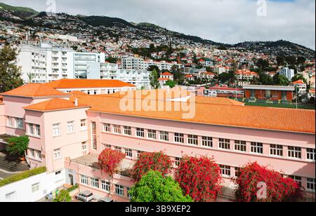 La prise de vue aérienne capture l'emblématique horizon au toit rouge de Funchal et l'historique Liceu de Jaime Moniz, encadré par des collines luxuriantes vitrine vibrante de Madère urbaine Banque D'Images