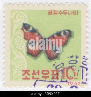 CORÉE DU NORD, RPDC - 1962 mars 13 : timbre-poste multicolore à 10 chon représentant des papillons : paon européen (Inachus Io, Aglais io), plus communément appelé simplement papillon paon, est un papillon coloré, trouvé en Europe et en Asie tempérée jusqu'à l'est du Japon. Le papillon paon réside dans une grande partie de son aire de répartition, hivernant souvent dans des bâtiments ou des arbres. Il apparaît donc souvent assez tôt au printemps. Le papillon paon a figuré dans la recherche dans laquelle le rôle des yeux comme mécanisme anti-prédateur a été étudié Banque D'Images