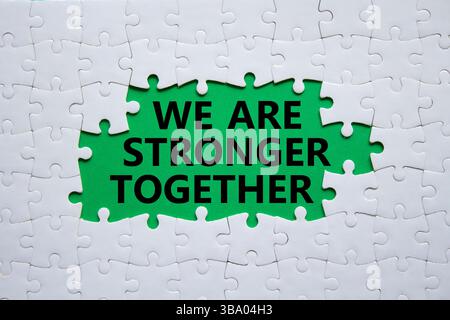 Nous sommes plus forts ensemble symbole. Puzzle blanc avec des mots nous sommes plus forts ensemble. Beau fond vert. Nous sommes plus forts ensemble concept. Copier Banque D'Images