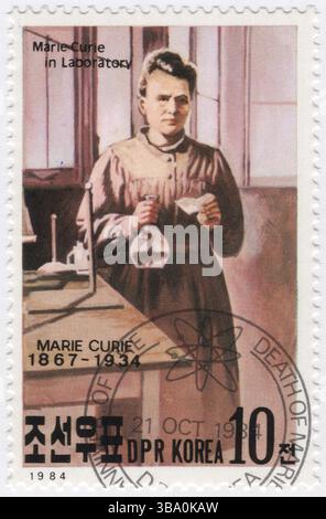 CORÉE DU NORD, RPDC - 1984 21 octobre : timbre-poste multicolore à 10 chon représentant une œuvre d'art Marie Curie (1867-1934) dans Laboratory. 50e anniversaire de la mort de Marie Salomea Skłodowska-Curie. Elle était une physicienne et chimiste polonaise et naturalisée française qui a mené des recherches pionnières sur la radioactivité. Marie a été la première femme à remporter un prix Nobel, la première personne à remporter un prix Nobel deux fois, et la seule personne à remporter un prix Nobel dans deux domaines scientifiques. Elle est, en 1906, la première femme à devenir professeure à l'Université de Paris Banque D'Images