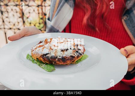 Gros plan sur une délicieuse pastilla au poulet, un plat traditionnel marocain, servi sur une assiette blanche Banque D'Images