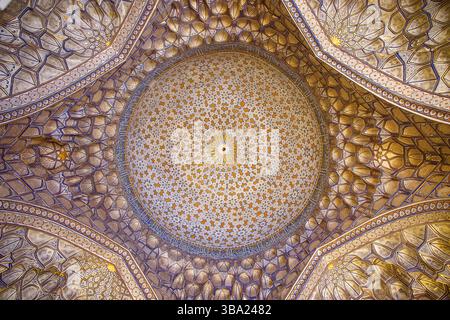 Regardant vers le haut le plafond intérieur richement décoré et doré d'un dôme dans la nécropole de Shah-i-Zinda à Samarcande, Ouzbékistan Banque D'Images