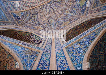 Une vue vers le haut sur l'entrée voûtée richement décorée et les galeries de la place Tilya-Kori Madrasan Registan à Samarcande en Ouzbékistan Banque D'Images
