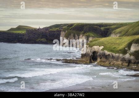 Château de Dunluce au bord de la falaise et des formations rocheuses calcaires sur White Rocks Beach, Causeway Coast, Wild Atlantic Way, Antrim, Irlande du Nord Banque D'Images