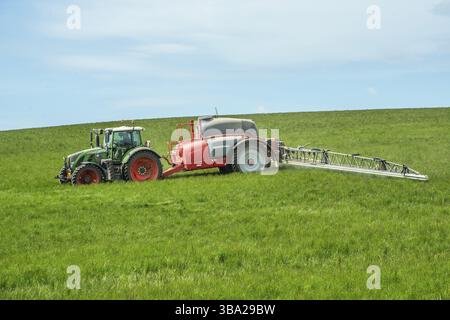 Agriculture de printemps, épandage d'engrais sur un champ avec des cultures avec un tracteur dans la municipalité d'Ystad, comté de Skane, Suède, Scandinavie, Europe Banque D'Images