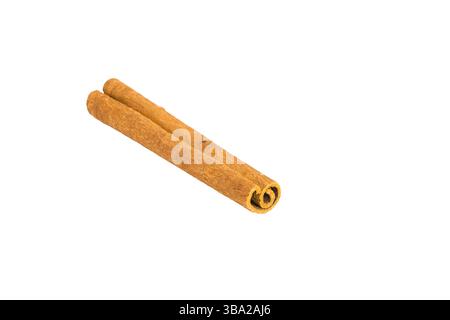 Morceaux d'écorce de cannelle dispersés sur une surface blanche, capturant leur texture rustique, leurs nuances brunes profondes et leurs formes organiques, idéales pour la cuisine et l'herba Banque D'Images