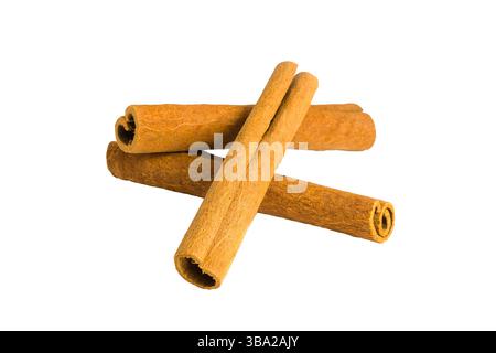 Gros plan de segments d'écorce de cannelle sur une surface blanche, mettant en évidence leur texture grossière, leurs motifs naturels et leurs tons chauds, idéal pour les pré sur le thème des épices Banque D'Images