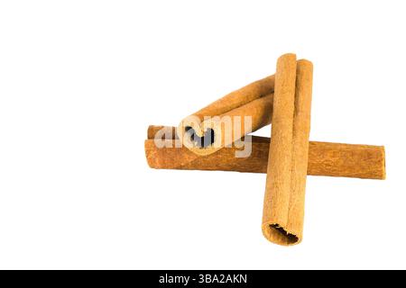 Divers morceaux d'écorce de cannelle affichés sur blanc, capturant leurs formes uniques, leur coloration naturelle et leurs surfaces texturées, idéales pour les épices et la cuisine Banque D'Images
