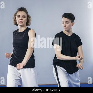 Deux femmes battante d'arts martiaux pratique dans la salle de gym. Taekwondo coach et étudiant dans la formation personnelle. Classe d'auto-défense pour les femmes. Entraînement des combattants Banque D'Images