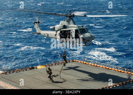 Les Marines américains affectés à la reconnaissance Company, 15th Marine Expeditionary Unit, à la corde rapide sur le pont d'envol du navire d'assaut amphibie USS Box Banque D'Images