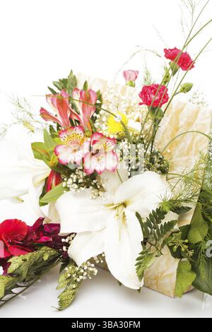 Bouquet de fleurs colorées mélangées dans un panier isolé sur blanc Banque D'Images