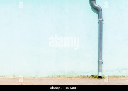 Gouttière de pluie descente contre le mur bleu comme fond Banque D'Images
