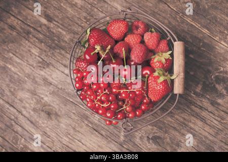 Fruits d'été en rouge panier métal sur la table Banque D'Images