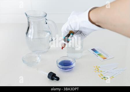 Photographies d'un kit d'analyse du pH de l'eau comprenant des gouttes indicatrices de couleur et un tableau comparatif, utilisé pour analyser l'acidité ou l'alcalinité de la boisson wa Banque D'Images