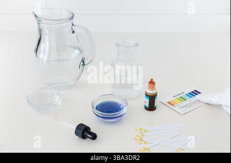 Photographies d'un kit d'analyse du pH de l'eau comprenant des gouttes indicatrices de couleur et un tableau comparatif, utilisé pour analyser l'acidité ou l'alcalinité de la boisson wa Banque D'Images
