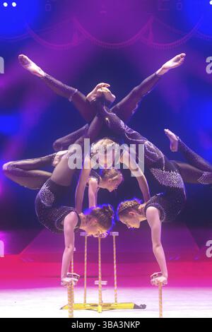Biélorussie, Gomel, 1er avril 2018. Les filles Gomel State Circus.Acrobatic effectuent un tour sous les lumières de scène bleues, Europe Banque D'Images