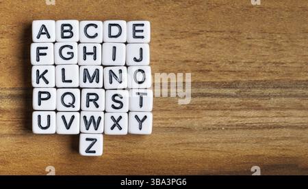 Ensemble de 26 petites lettres de perles blanches - alphabet entier - sur table en bois, vue d'en haut, espace pour le texte côté droit, Liptovsky Mikulas, Slovaquie, Europ Banque D'Images