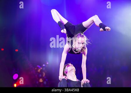 Biélorussie, Gomel, 1er avril 2018. Les filles Gomel State Circus.Acrobatic effectuent un tour sous les lumières de scène bleues, Europe Banque D'Images