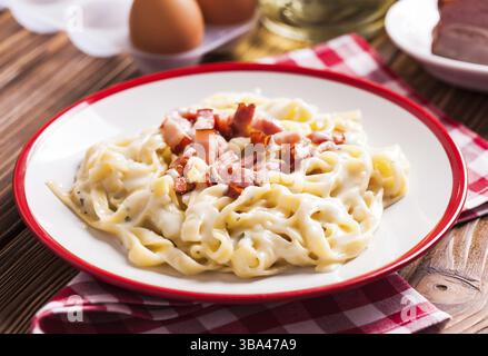 Cuisine traditionnelle italienne - tagliatelle de pâtes carbonara sur une assiette Banque D'Images