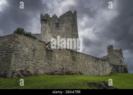 Canon sortant du mur de fortification du château de Ross du 15ème siècle avec des nuages de tempête dramatiques en arrière-plan, anneau de Kerry, Killarney, Irlande, E. Banque D'Images