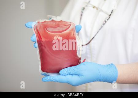 Le plasma sanguin au centre de la transfusionnologie et du don. fermez la poche de sang dans le laboratoire dans les mains Banque D'Images