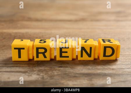 Mot tendance fait de cubes jaunes avec des lettres sur une table en bois Banque D'Images
