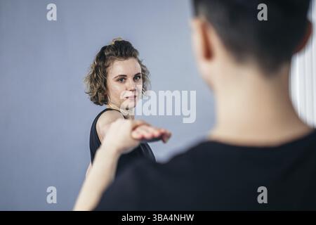 Deux femmes battante d'arts martiaux pratique dans la salle de gym. Taekwondo coach et étudiant dans la formation personnelle. Classe d'auto-défense pour les femmes. Entraînement des combattants Banque D'Images
