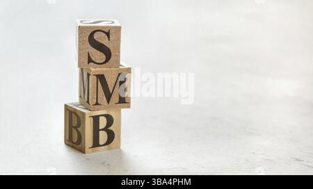 Pile avec trois cubes en bois - lettres SMB signifiant petite à moyenne entreprise sur eux, espace pour plus de texte / images sur le côté droit, Liptovsky Hrado Banque D'Images
