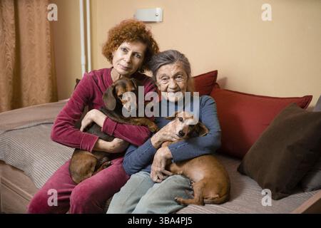 Le thème est la thérapie animale, la prise en charge des personnes âgées atteintes de démence et de la maladie d'Alzheimer. Les femmes adultes passent du temps avec des mères âgées et des chiens d'animaux de compagnie à l'irb Banque D'Images