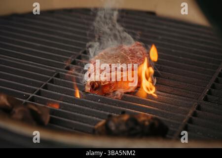 Griller le steak New York Strip sur une flamme nue sur le barbecue. Banque D'Images
