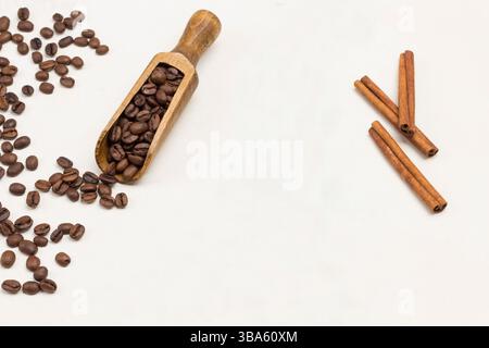 Grains de café dans une pelle en bois et sur la table. Fond blanc. Vue de dessus Banque D'Images