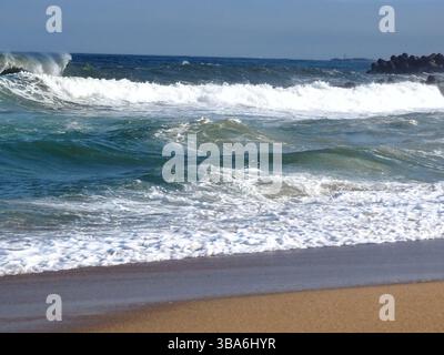 Vagues de l'océan Pacifique se brisant sur la plage de sable d'Iwaki à Fukushima Japon avec surf, mousse blanche et paysage marin côtier sous ciel clair Banque D'Images