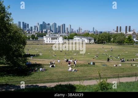 Vue panoramique du quartier financier de Canary Wharf au-delà du National maritime Museum et de l'Old Royal Naval College depuis le point de vue de Greenwich Park le 10 mai 2025 à Londres, Royaume-Uni. Canary Wharf est une zone située près de l'île des chiens dans le quartier londonien de Tower Hamlets et est définie par la Greater London Authority comme faisant partie du quartier central des affaires de Londres. Avec la City de Londres, elle constitue l'un des principaux centres financiers du Royaume-Uni et du monde, avec de nombreux immeubles de grande hauteur, dont le troisième plus haut du Royaume-Uni, One Canada Square. Banque D'Images