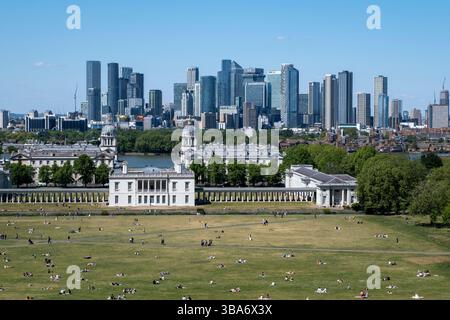 Vue panoramique du quartier financier de Canary Wharf au-delà du National maritime Museum et de l'Old Royal Naval College depuis le point de vue de Greenwich Park le 10 mai 2025 à Londres, Royaume-Uni. Canary Wharf est une zone située près de l'île des chiens dans le quartier londonien de Tower Hamlets et est définie par la Greater London Authority comme faisant partie du quartier central des affaires de Londres. Avec la City de Londres, elle constitue l'un des principaux centres financiers du Royaume-Uni et du monde, avec de nombreux immeubles de grande hauteur, dont le troisième plus haut du Royaume-Uni, One Canada Square. Banque D'Images