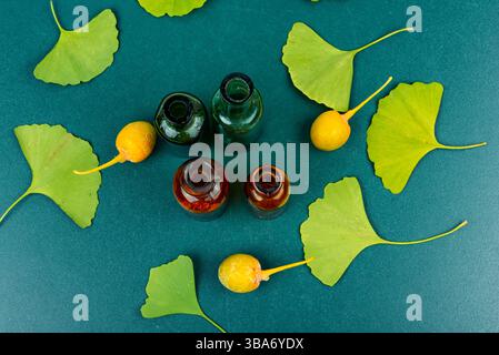 Pot en verre avec extrait du ginkgo avec des feuilles et des noix jaunes. Concept de phytothérapie naturelle. Vue de dessus Banque D'Images