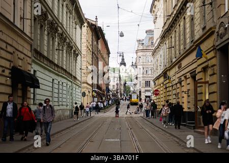 Lviv, Ukraine - 04 mai 2025 : rue de la ville européenne bondée avec tramway, piétons et architecture historique à Lviv, Ukraine. Banque D'Images