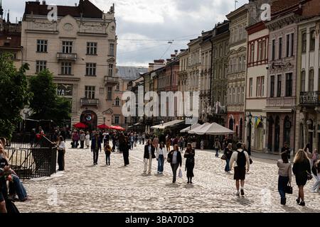 Lviv, Ukraine - 04 mai 2025 : charmante scène urbaine de rue avec architecture historique, route pavée, et des individus se promenant à Lviv, Ukraine. Banque D'Images