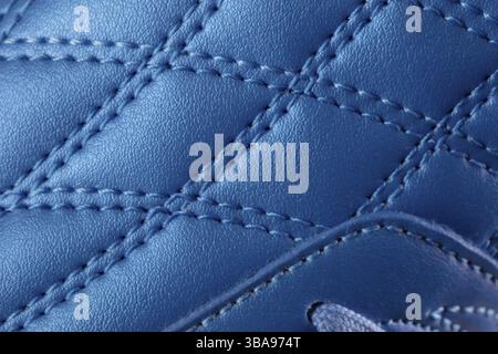 La texture macro d'une sneaker en cuir bleu avec coutures. Une partie de la chaussure de sport est un gros plan Banque D'Images