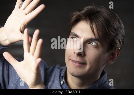Un homme montre des gestes avec ses mains Banque D'Images