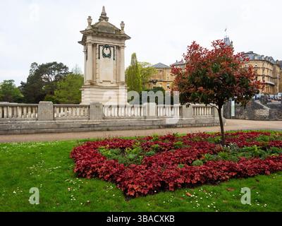 Le mémorial de guerre avec un arbre de brousse fumé Cotinus coggygria et Heuchera au premier plan, Central Gardens, Bournemouth, Dorset, Angleterre, Royaume-Uni, mai 2023 Banque D'Images