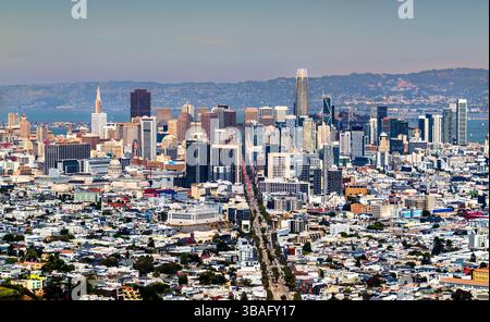 Vue panoramique claire sur les gratte-ciel du centre-ville de San Francisco avec des gratte-ciel proéminents et des bâtiments historiques le long du couloir de Market Street, vu d'en haut lors d'une journée d'été lumineuse avec les collines d'East Bay en arrière-plan Banque D'Images